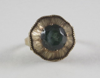 A gold dress ring set a green stone