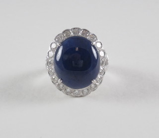 A lady's 18c white gold dress ring set a cabouchon cut sapphire surrounded by diamonds