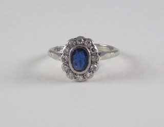 A lady's 18ct white gold dress ring set a sapphire surrounded by diamonds
