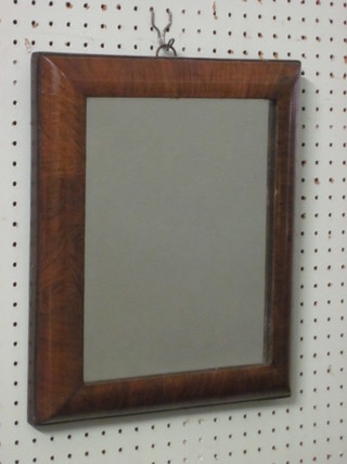 A rectangular plate mirror contained in a walnut cushion shaped frame 14" x 12"