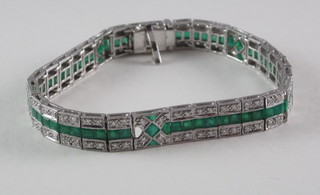 A white gold bracelet set emeralds and diamonds