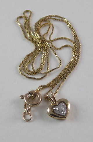A fine gold chain hung a heart shaped pendant set a diamond