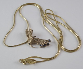 A fine gold chain hung a pendant in the form of a humming bird