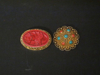 A gilt metal filigree brooch and a Redware brooch