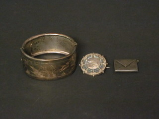 A silver bracelet, a silver stamp case in the form of an envelope  and a silver brooch