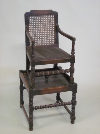 A childs 1930's oak open arm training chair with woven cane  back, raised on turned and block supports