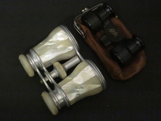 A pair of mother of pearl mounted opera glasses by Negretti & Zambra together with a pair of Elgis opera glasses