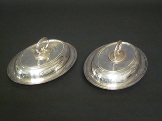 A pair of silver plated oval entree dishes and covers
