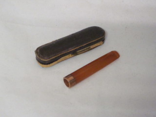 An amber and gold mounted cigar holder, cased