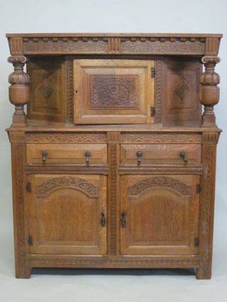 A carved honey oak court cupboard fitted 2 long drawers above  double cupboard 47"