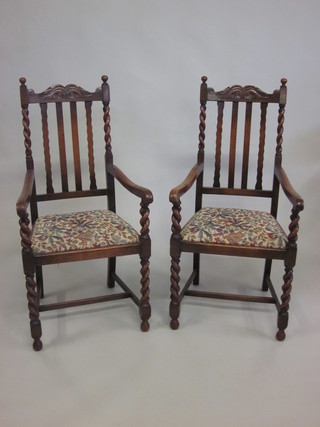 A pair of oak stick and rail back carver chairs with upholstered  drop in seats