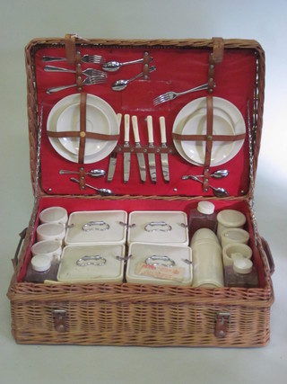 A wicker picnic hamper containing plastic boxes and plates by Bamdalasta