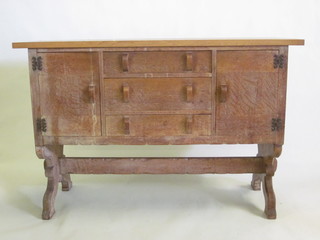 An Arts & Crafts style limed oak sideboard by Waring &  Gillows, fitted 3 long drawers flanked by a pair of cupboards,  raised on trestle supports with H framed stretcher 58"