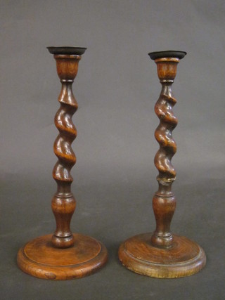A pair of oak spiral turned candlesticks with metal sconces 12"