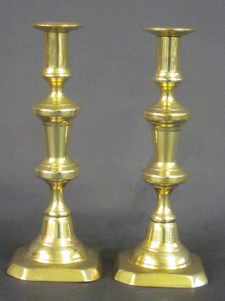 A pair of brass candlesticks with ejectors 10"