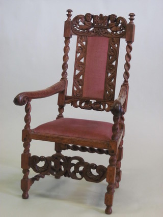 A carved oak Carolean style open armchair with upholstered seat  and back