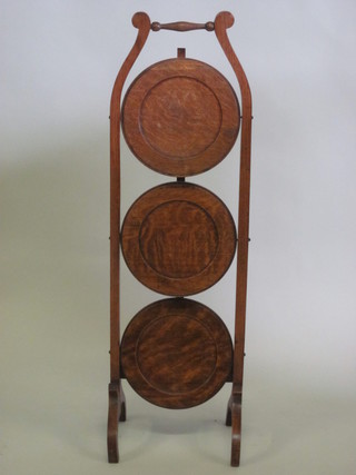A honey oak circular 3 tier folding cake stand