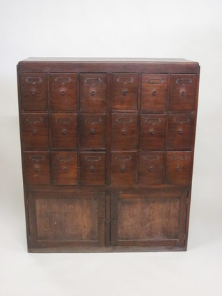 An Edwardian oak card index chest fitted 18 drawers above a  double cupboard 42"