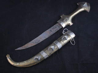An Eastern dagger with 7" curved blade contained in a brass and white metal scabbard