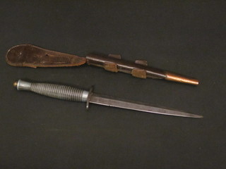 A Fairburn Sykes type fighting knife with 7" blade, complete  with leather scabbard