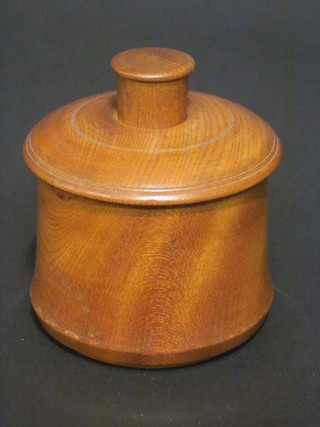 A cylindrical wooden patented box containing 6 balls 3"