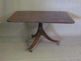 A 19th Century mahogany rectangular breakfast table, raised on  pillar and tripod base ending in brass caps and castors, 52"
