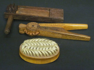 A wooden rattle, pair of carved wooden nut crackers and a  wooden clothes brush