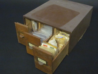 A 3 draw table top filing index chest containing loose stamps