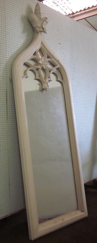 A Gothic style arched plate mirror contained in a white resin  frame with fleur de lis decoration 86"