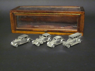 A mahogany finished display cabinet containing 4 pewter models  of Rolls Royce