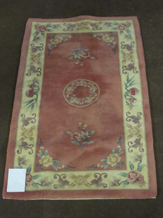 A peach ground and floral patterned Chinese rug 61" x 36"