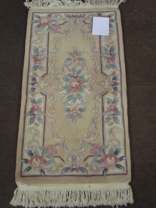 A peach ground floral patterned Chinese rug 48" x 24"