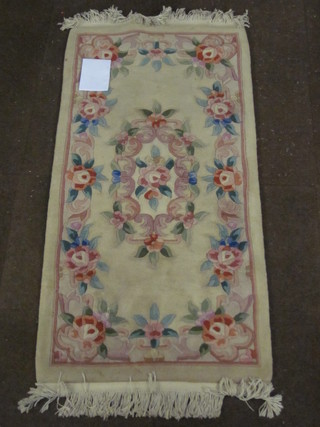 A cream coloured and floral patterned Chinese rug 56" x 27"