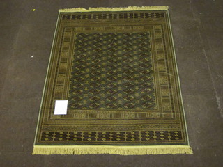 A green ground machine made Bokhara style rug 66" x 49"