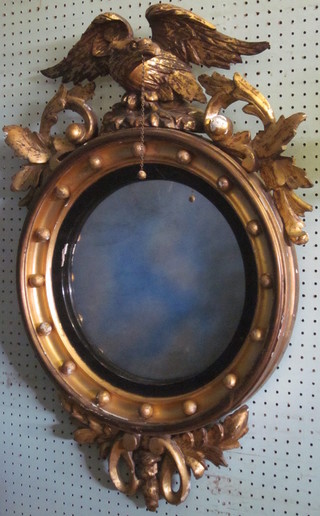 A circular convex plate wall mirror contained in a ball studded  gilt frame surmounted by a figure of an eagle 19"   ILLUSTRATED