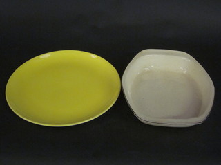 A yellow glazed circular Poole Pottery charger with dolphin  mark 13" together with a yellow glazed casserole dish 13"