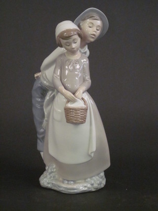 A Nao figure of a standing boy and girl with basket 12"