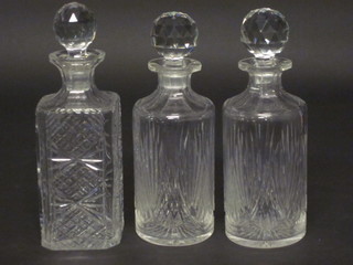 A pair of cylindrical cut glass decanters and stoppers together  with a cut glass spirit decanter
