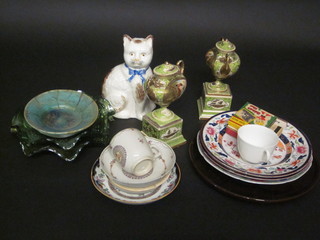 A pair of Berlin style oval twin handled urns raised on square  bases 8", a Staffordshire figure of a seated cat 7", 2 green  carnival glass bowls, various decorative ceramics