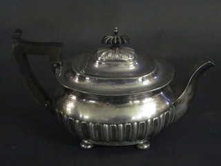 An oval Britannia metal teapot with demi-reeded decoration,  raised on 4 bun feet