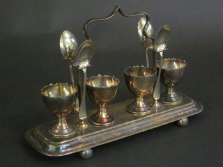 A rectangular 4 piece silver plated egg cruet with spoons