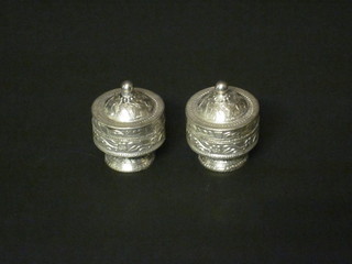 A pair of Eastern embossed white metal jars and covers, bases marked 800 1 1/2"