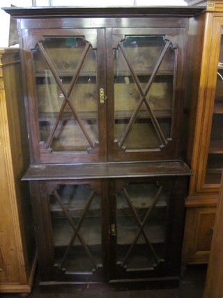 A 19th Century mahogany display cabinet on cabinet, the upper section with moulded cornice, the interior fitted adjustable  shelves enclosed by astragal glazed panelled doors, raised on a  platform base 42"