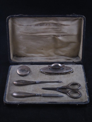 A 5 piece manicure set with silver handles comprising nail file, buffer, cleaner, pair of scissors and circular jar and cover,  Chester 1913