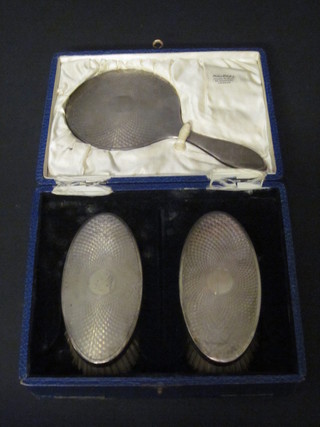 A 3 piece silver backed dressing table set with hand mirror and  pair of hairbrushes, London 1927, boxed