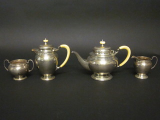 A circular silver 4 piece tea service with engraved decoration comprising teapot, hotwater jug, twin handled sugar bowl and  cream jug, raised on circular spreading feet with ivory handles  and finials, Sheffield 1930, 1931 and 1932, 52 ozs   ILLUSTRATED