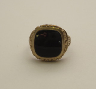 A gold signet ring set a square cut black stone