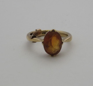 A gold dress ring set an amber coloured oval stone