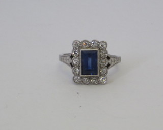 A platinum dress ring set a rectangular cut sapphire surrounded  by diamonds