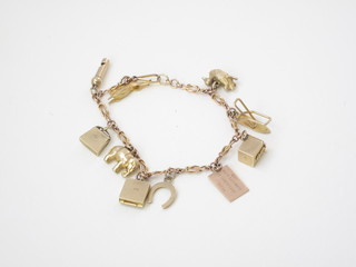 A gold curb link charm bracelet hung 10 various charms
